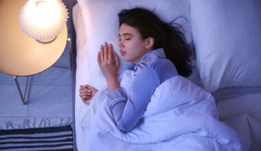 Young woman sleeping in bedroom at night, top view