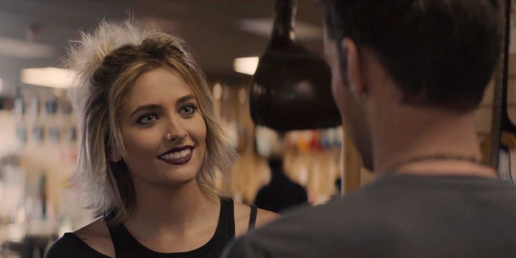 Nelly (Paris Jackson) smiling at someone in Gringo.