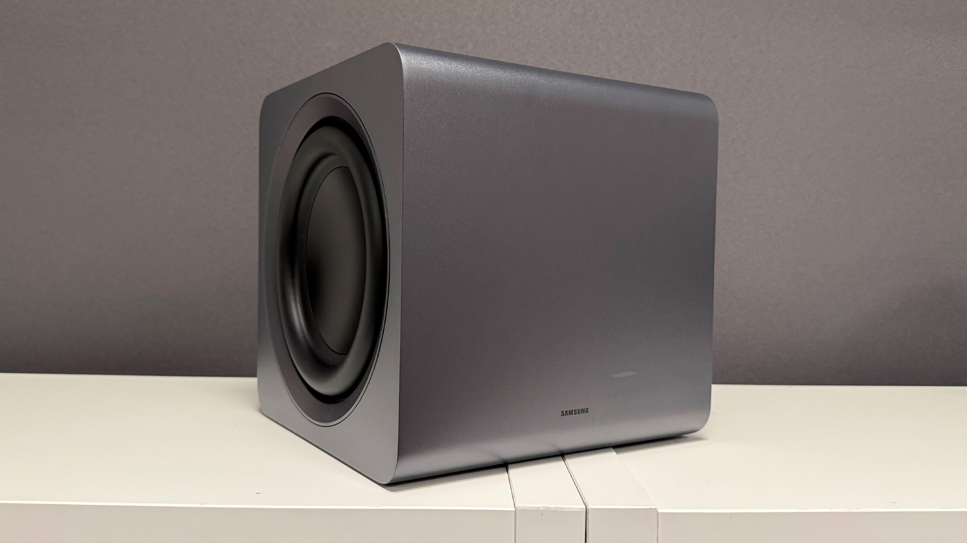 Samsung HW-Q990H soundbar package subwoofer on white wooden shelf unit