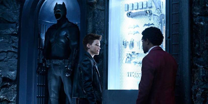 A Batsuit in the background of Batwoman