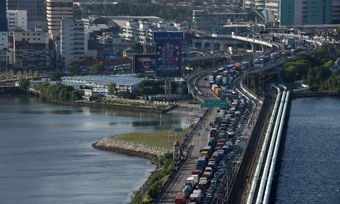 Vehicles form a long queue to enter Woodlands checkpoint in Singapore on March 17, 2020, from across the causeway of the southern Malaysian state of Johor. Photo by AFP