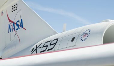 A close-up of NASA's X-59 tail showing a NASA graphic on the tail, X-59 on the side of the jet engine, and a Freedom 250 logo toward the front of the engine.
