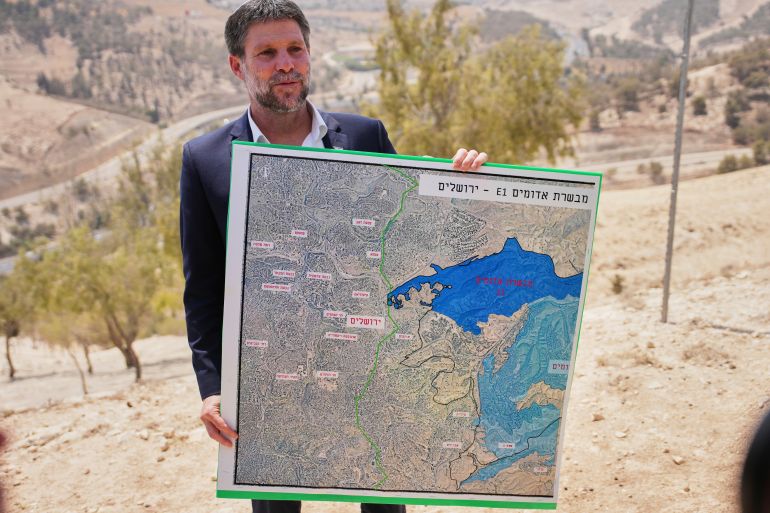 FILE - Israeli Finance Minister Bezalel Smotrich holds a map that shows the E1 settlement project during a press conference near the settlement of Maale Adumim, in the Israeli-occupied West Bank, Aug. 14, 2025. (AP Photo/Ohad Zwigenberg, File)