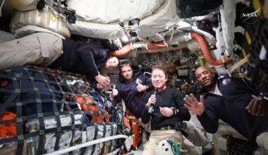 Four astronauts float amongst equipment and supplies inside the Orion spacecraft.