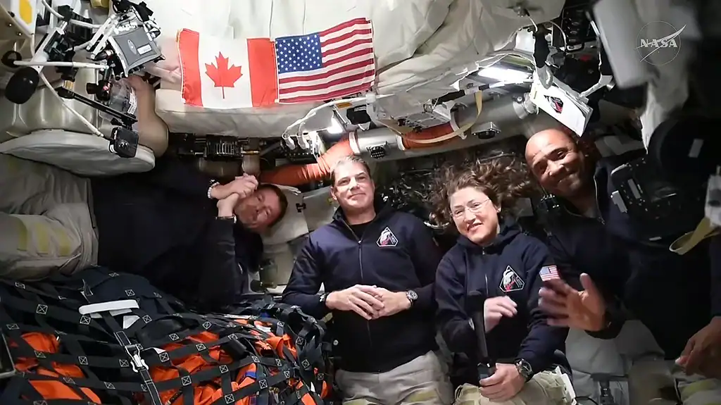 Astronauts inside the Orion capsule for the Artemis II mission posed together for a photo.