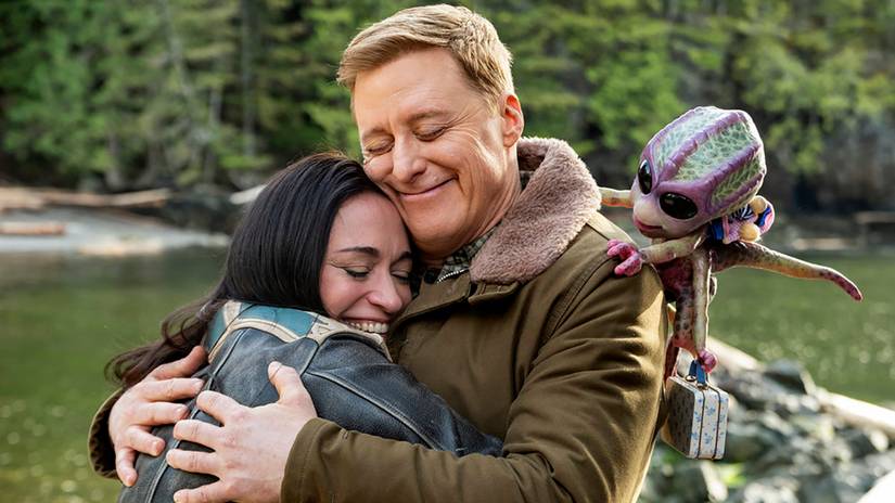 Asta, Harry and Bridget smiling while they hug goodbye in Resident Alien season 4 finale YT