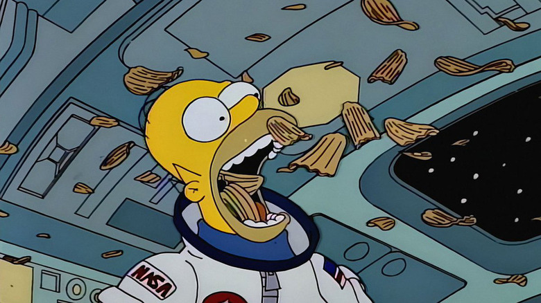 Homer Simpson as an astronaut eats floating chips on The Simpsons