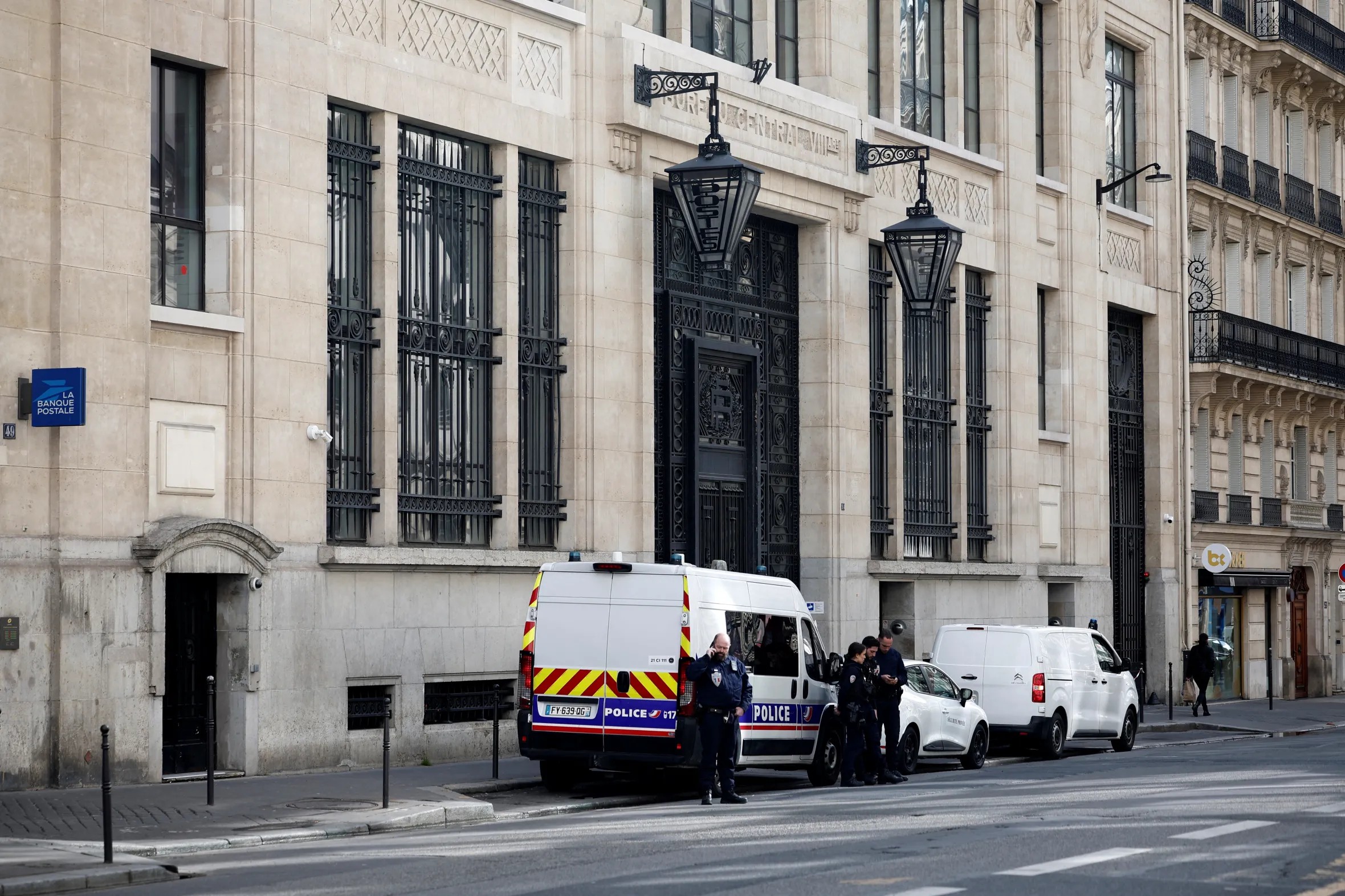 Police officials and vehicles outside a Bank of America building in Paris after a bomb attack attempt.