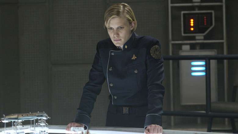 Kara Thrace (Katee Sackhoff) stands over a lit up table in Battlestar Galactica (2004)
