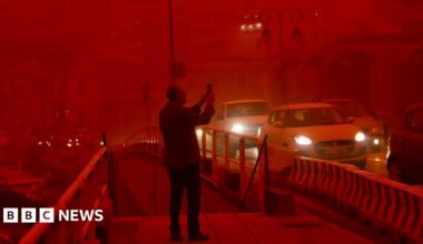 A man takes a picture while cars drive with their headlights on in red air in the city of Heraklion, Crete. Photo: 1 April 2026