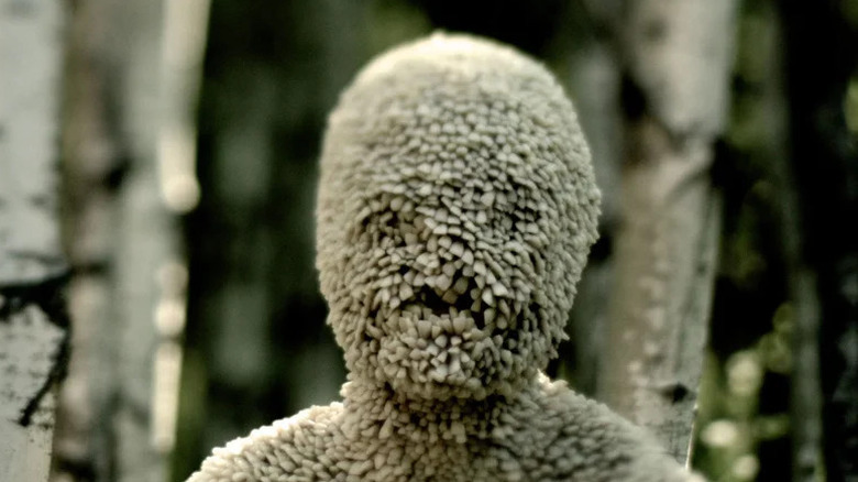 A man made of teeth stands in the woods in Channel Zero