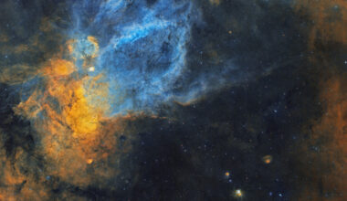 Large clouds of interstellar gas and dust of various shapes and sizes cover the image. A cloud shaped like a bubble 
sits atop the image, while a cloud shaped like a claw is in the middle.