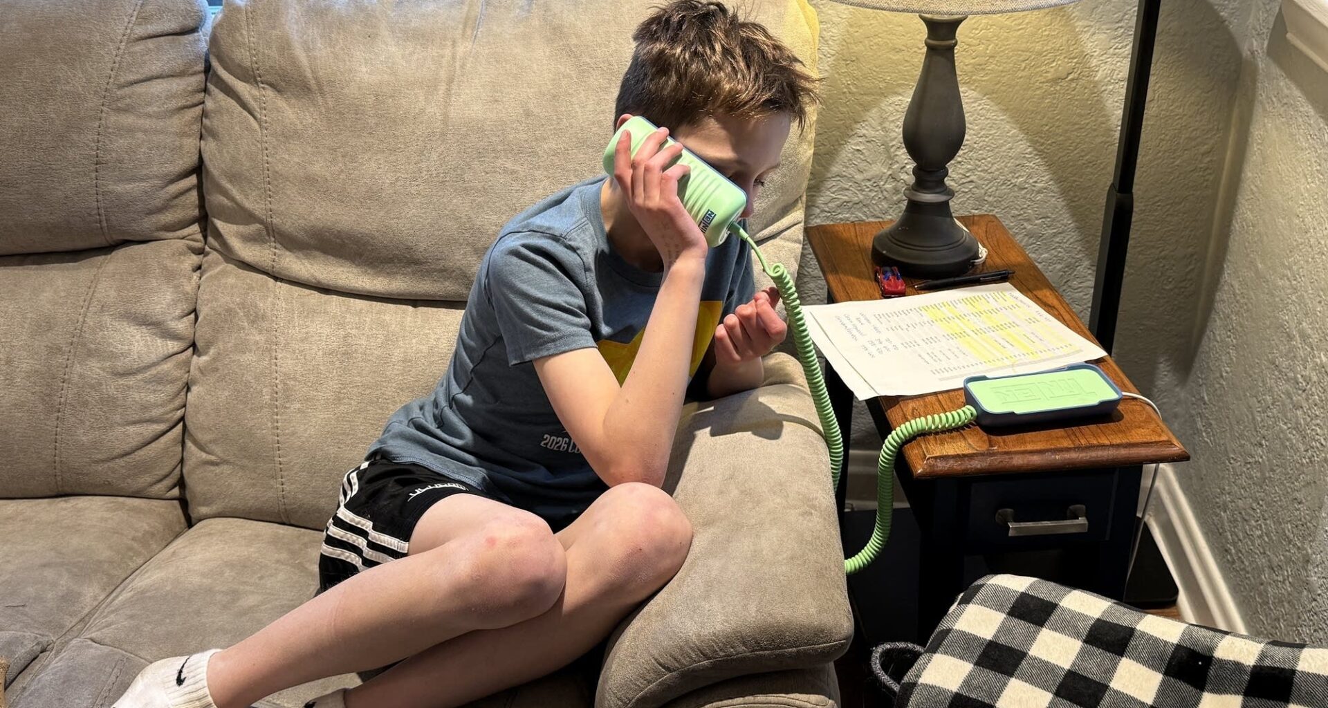 Jake Zobec, a Denver fourth-grader, speaks to his grandma on a landline telephone.