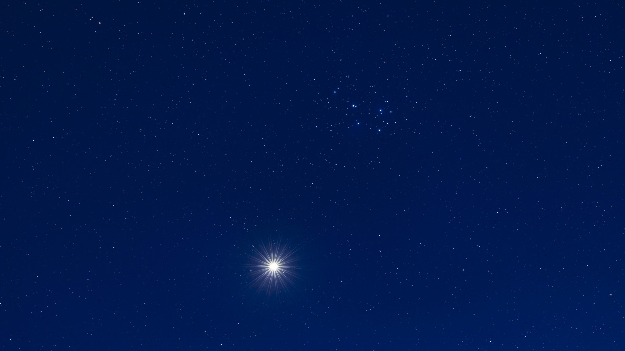 A close passage of Venus by the Pleiades star cluster (M45), set in the deep blue twilight