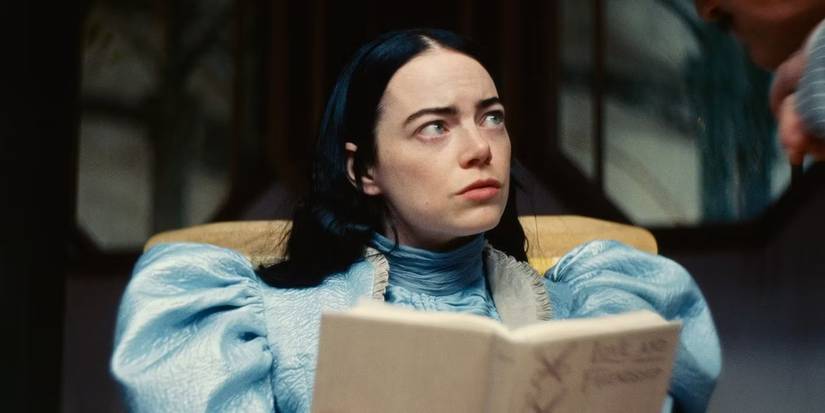 Emma Stone as Bella Baxter in Poor Things looking up while reading a book.