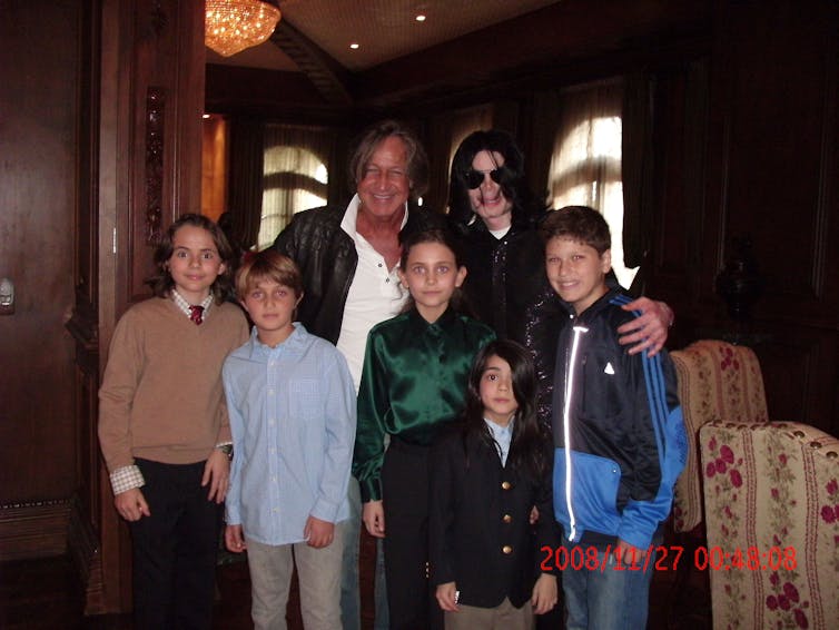 Michael Jackson and another man pose with five children.