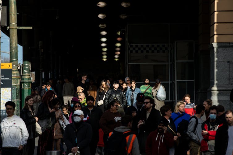 A crowd of commuters walking in and out of Melbourne's Flinders Street station.