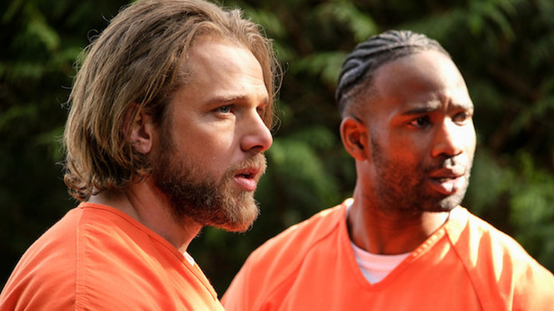 Max Thieriot as Bode and W. Tré Davis as Freddy wearing orange prison jumpsuits