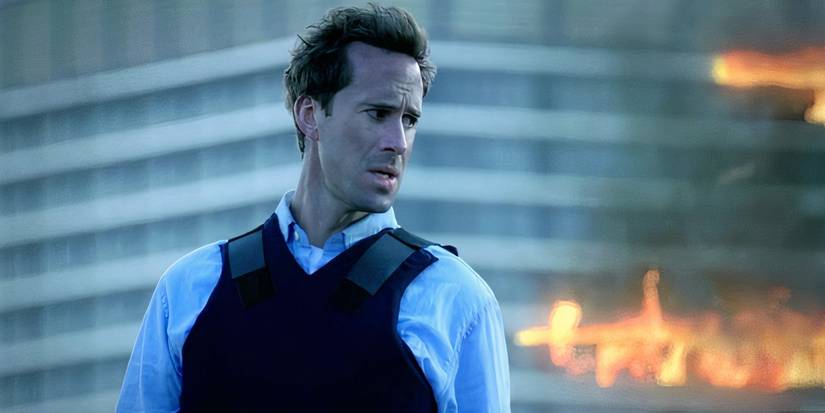 Agent Mark Benford, played by Joseph Fiennes, stands in front of a burning building in FlashForward.