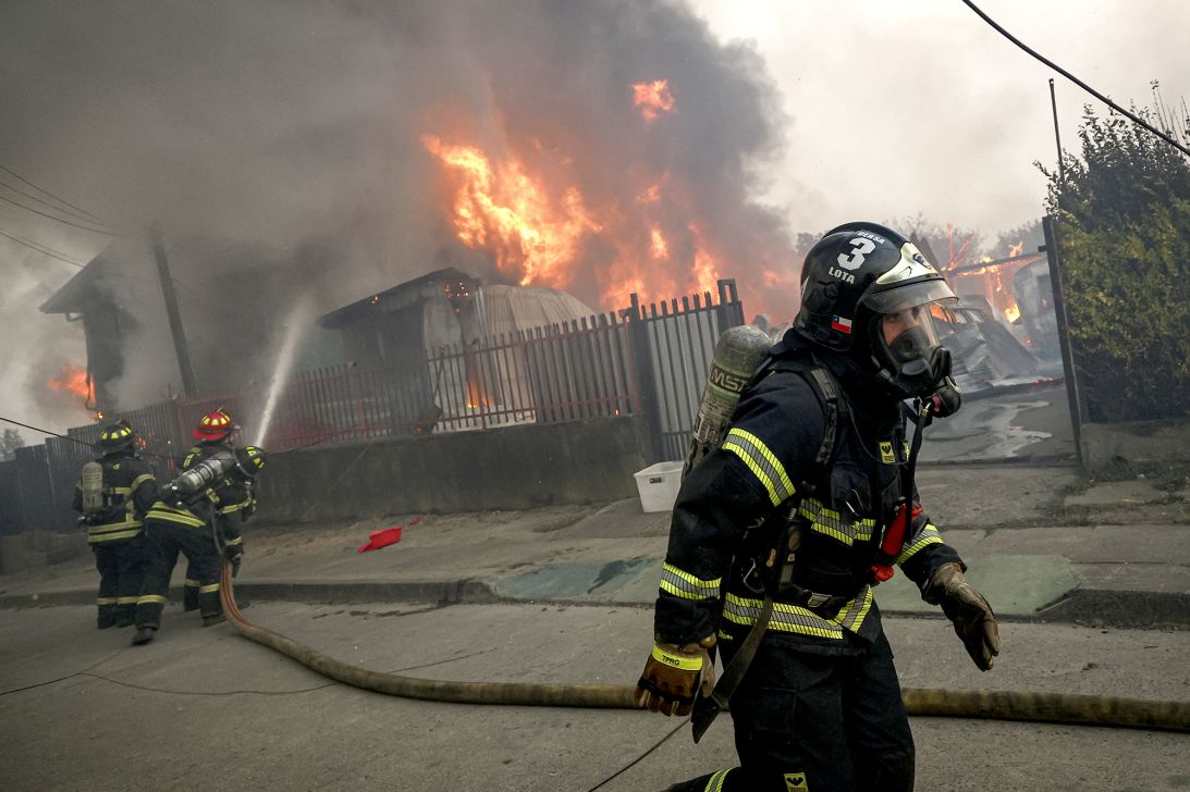 Flames destroy homes following wildfires in the municipality of Penco, Chile, on January 18, 2026.