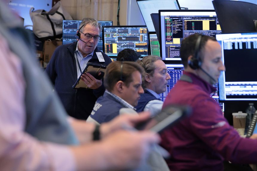 Traders work on the floor of the New York Stock Exchange during morning trading on April 17, 2026 in New York City.