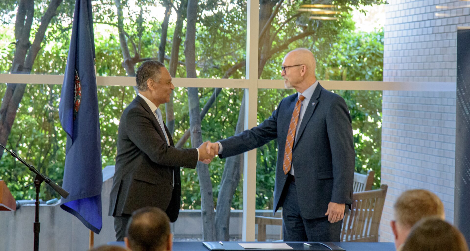 Mark Johnson, left, interim CEO of UNOS, and John Koelling, director of the Aeronautics Research Directorate at NASA's Langley Research Center, shake hands during a signing ceremony marking an agreement to study drone transport for organs.
