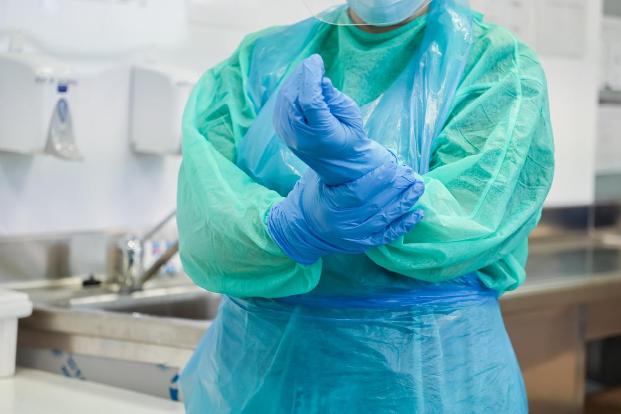 Healthcare worker in gown and gloves