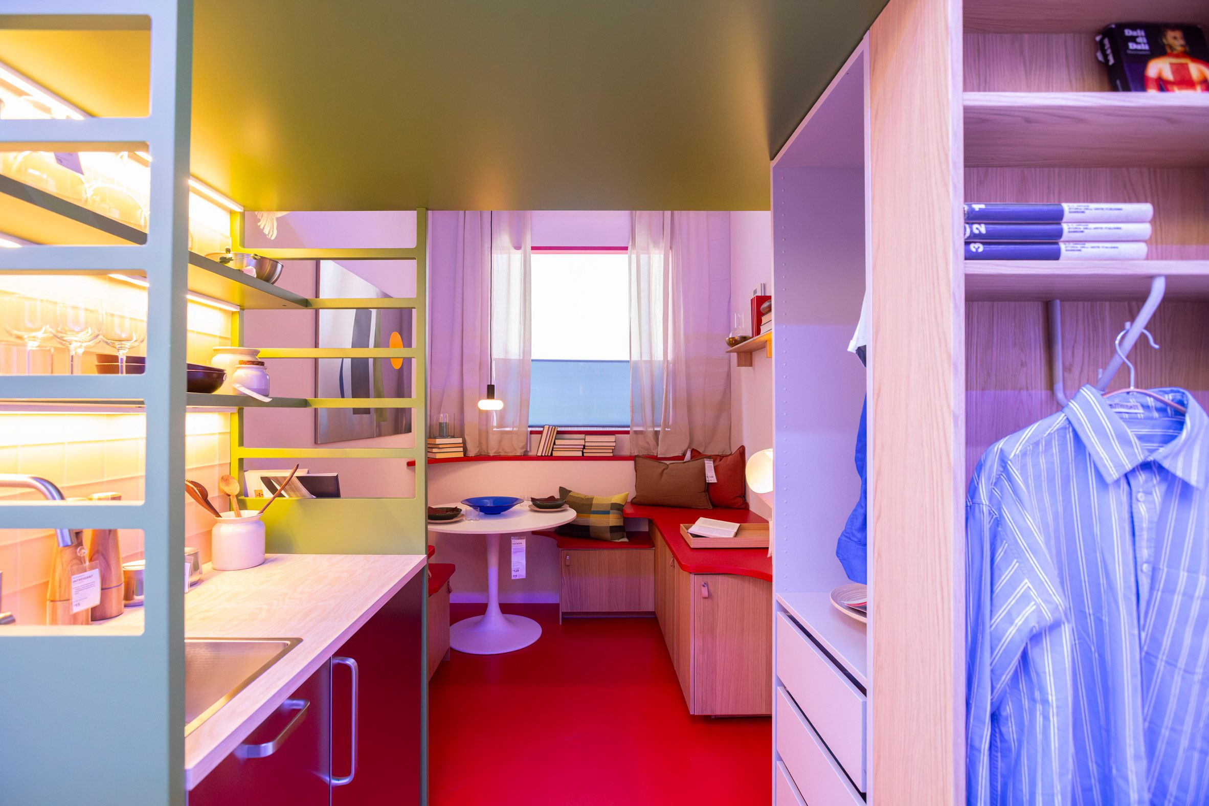 A compact, colourful studio with built-in seating and red flooring