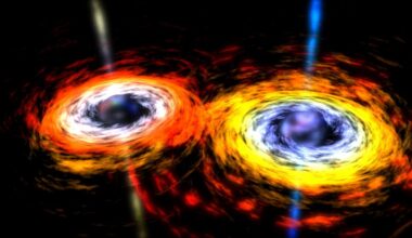 Image of two dark spheres surrounded by bright materail, swirling in towards a collision.