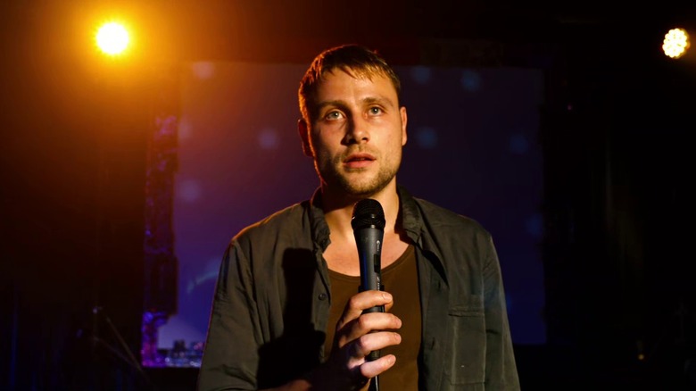 Wolfgang Bogdanow standing on a karaoke stage and holding a microphone on Sense8 S1E4