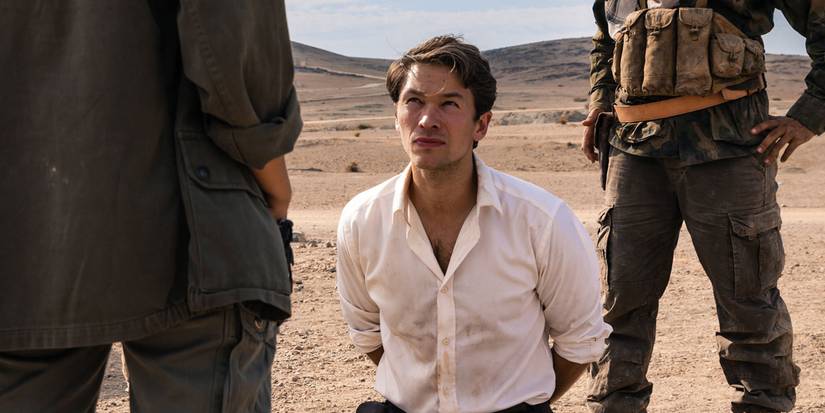 Jakob Oftebro kneeling on the ground between two soldiers in Agent Hamilton