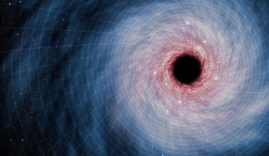 A swirl of blue and red light around a dark black hole in the right side of the image sits on a white grid of blocks showing the fabric of spacetime