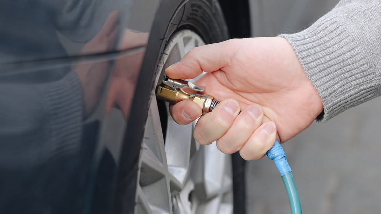 Inflating car tire with air compressor.