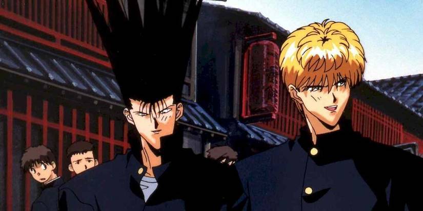 Main characters from Kyou Kara Ore Wa!! in matching dark blue jackets standing in a street with onlookers. 