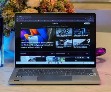 The Lenovo Chromebook Plus on table with flower in background