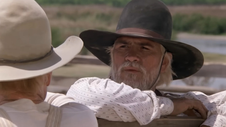 Woodrow Call (Tommy Lee Jones) looks at Gus McCrae (Robert DuVall while leaning on a fence in Lonesome Dove