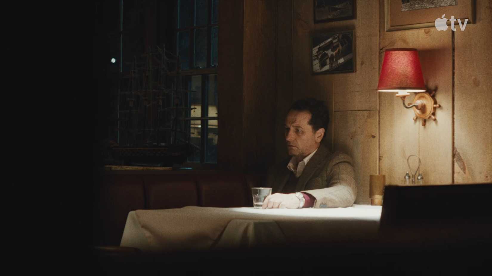 Mayor Tom Loftis (Matthew Rhys) sitting at a table in Apple TV Widow's Bay