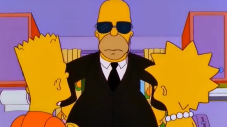 Homer Simpson stares down his kids Bart and Lisa dressed as a bpdyguard on The Simpsons