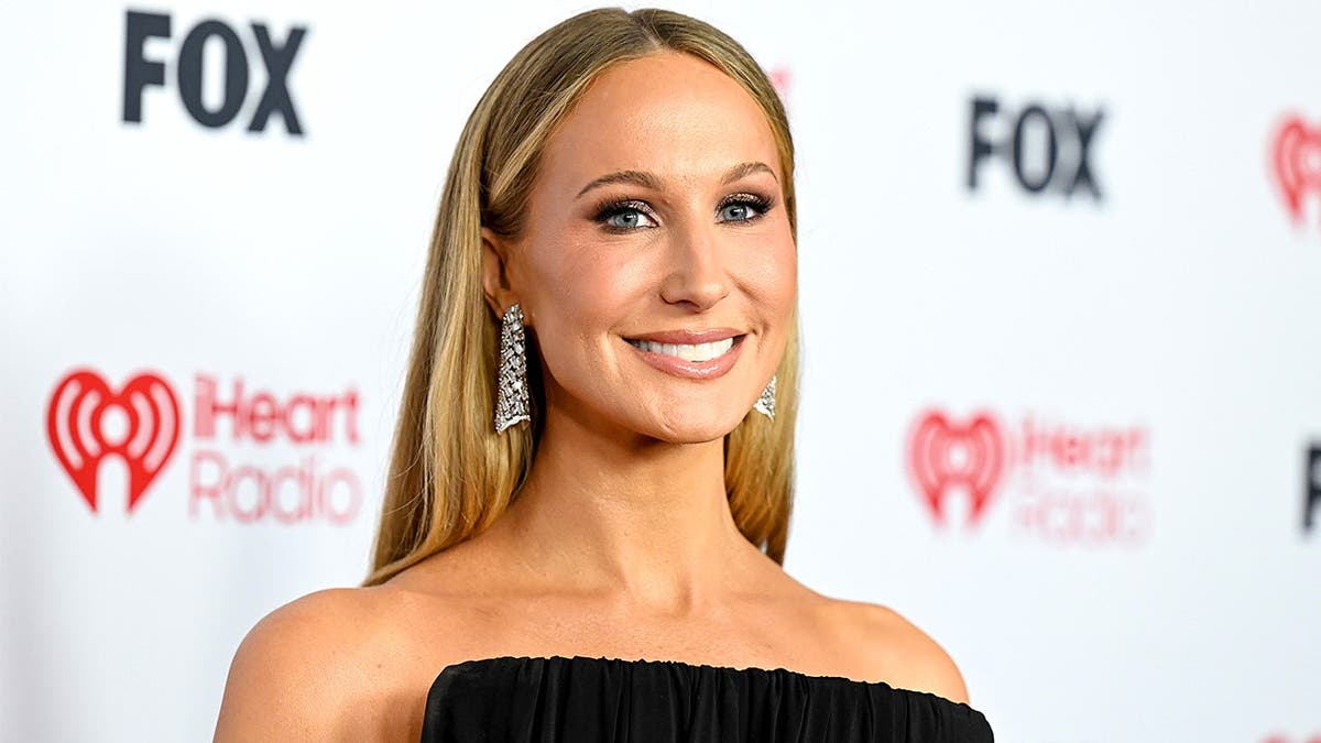 Nikki Glaser poses on red carpet at iHeartRadio Music Awards.