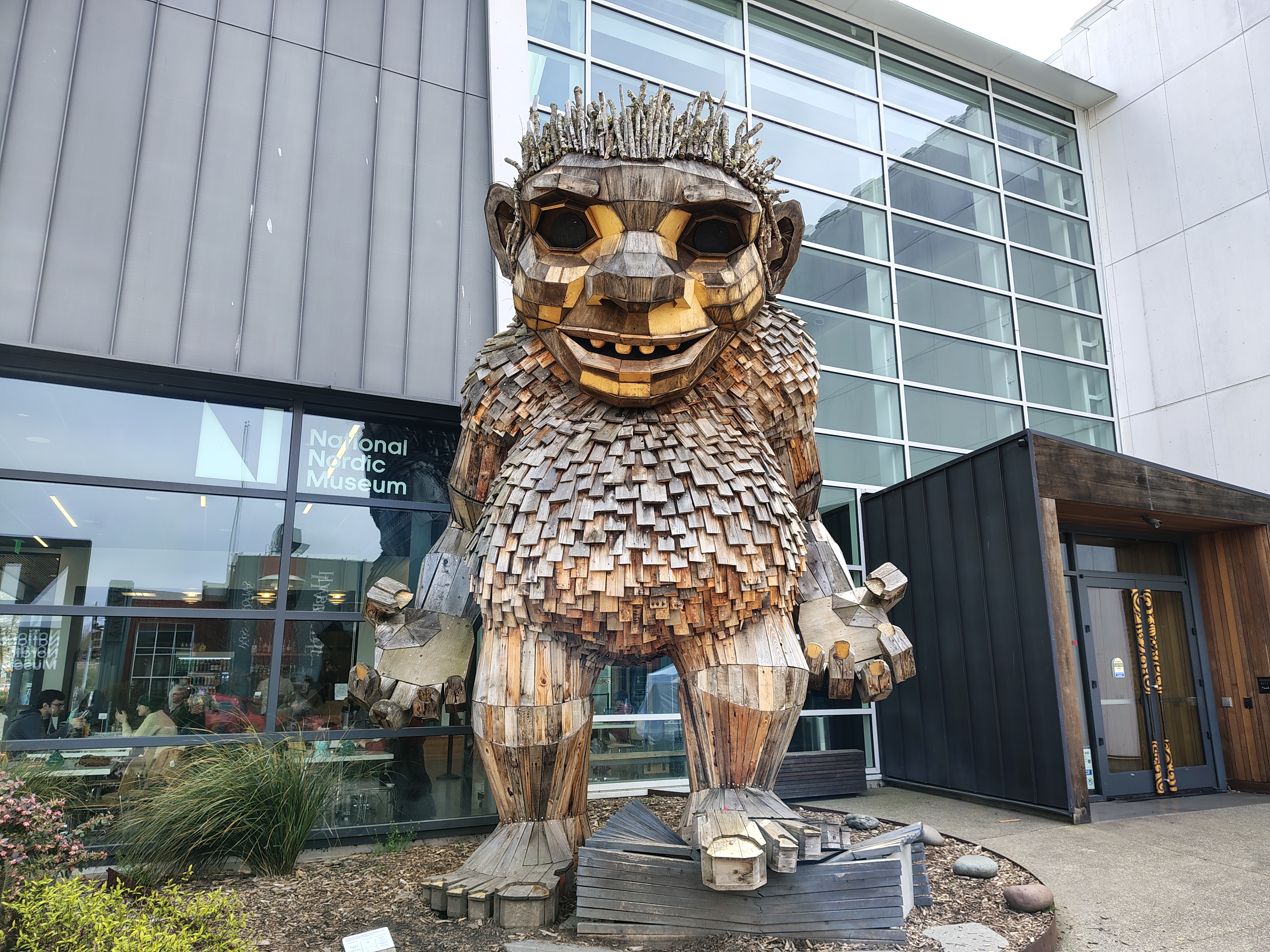 A large, wooden troll statur in front of a building