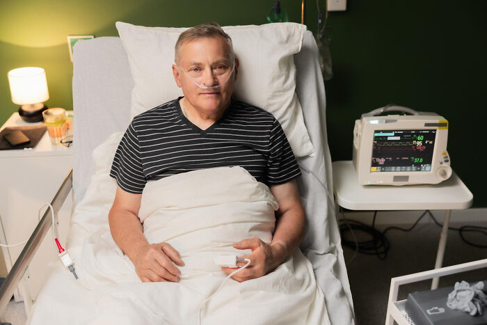 Elderly male patient in hospital bed with oxygen and heart monitor, illustrating surgical staff patient sedation confessions.