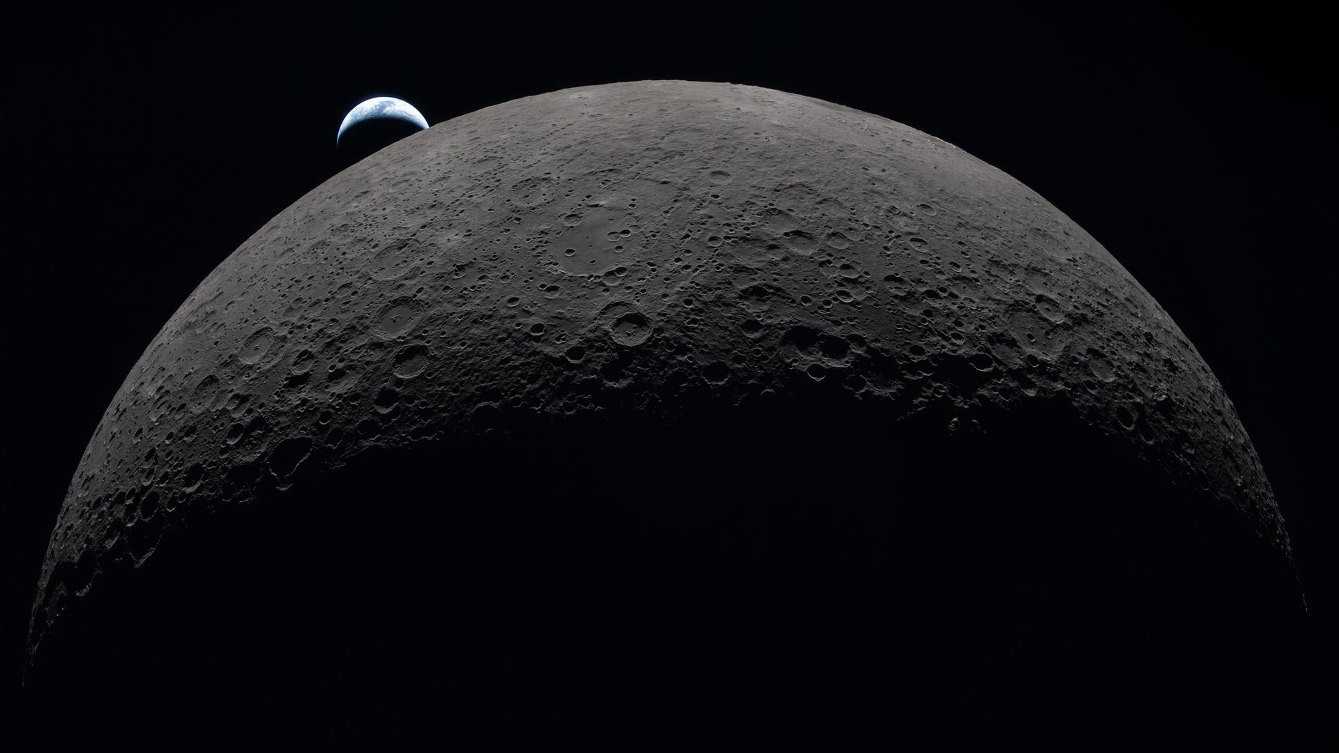 photo taken from beyond the moon, showing a tiny earth hovering above a huge moon