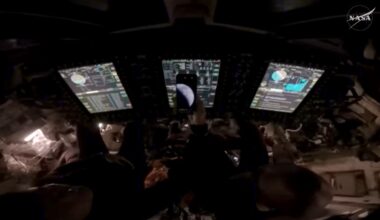 NASA astronauts Reid Wiseman and Victor Glover show a photo of Earth taken just moments after the Orion spacecraft ignited its thrusters for a final burn for 8 seconds, pushing Artemis II toward Earth. Credit: NASA