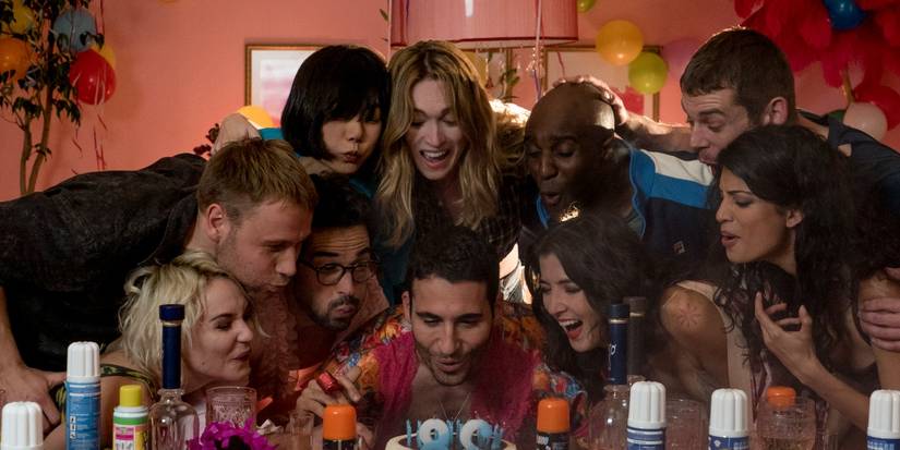 The cast of Sense8 blow out the candles on a birthday cake.