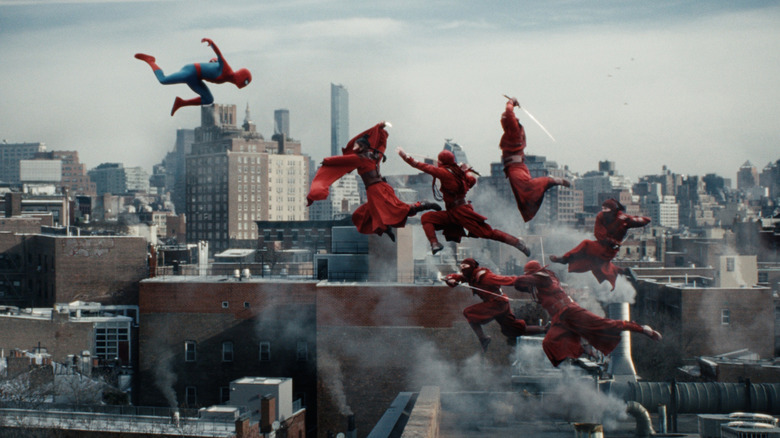 Tom Holland as Peter Parker wearing his superhero suit and attacking a group of ninjas in midair in Spider-Man: Brand New Day