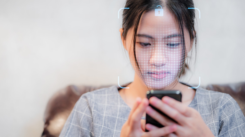 Woman using a face unlock feature as it scans a 3d model of her face