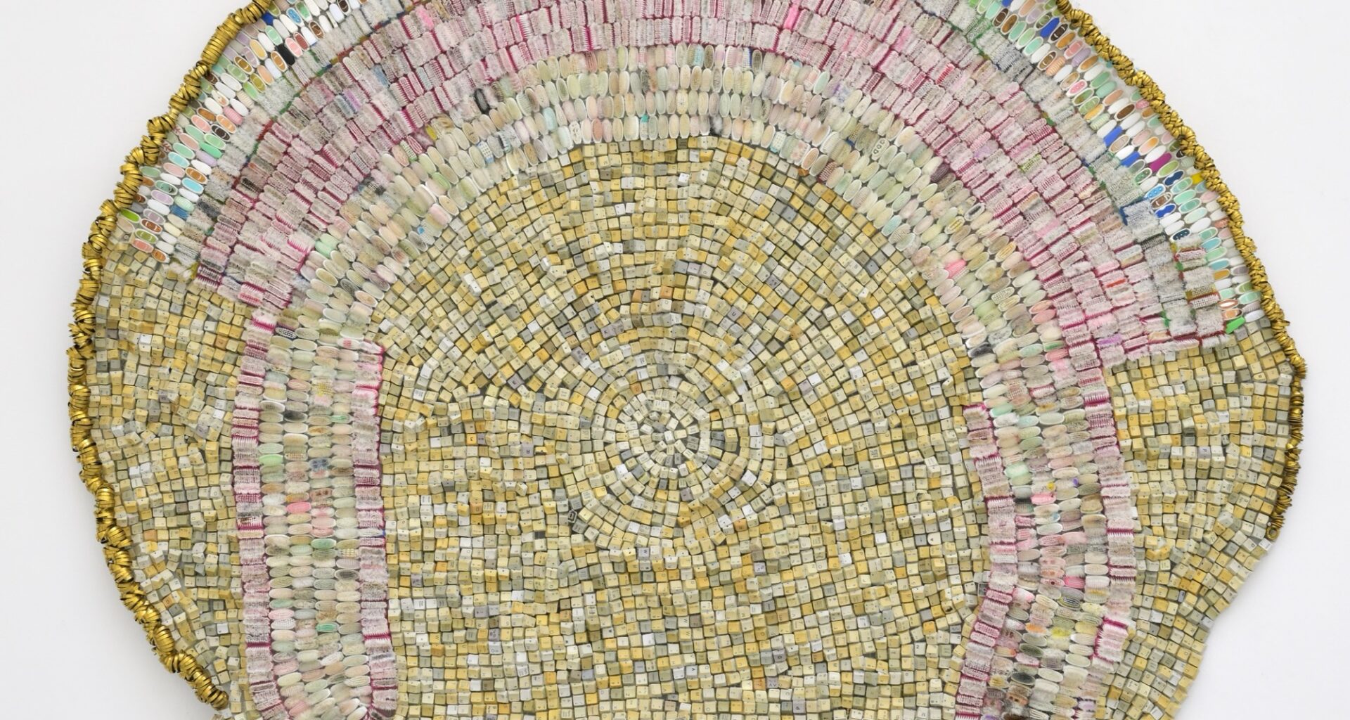 an abstract wall-installed artwork by Moffatt Takadiwa made from computer keyboard keys, combs, toothbrush heads, and metal pieces