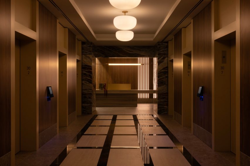 Reflective and brushed metals are layered in an elevator bank