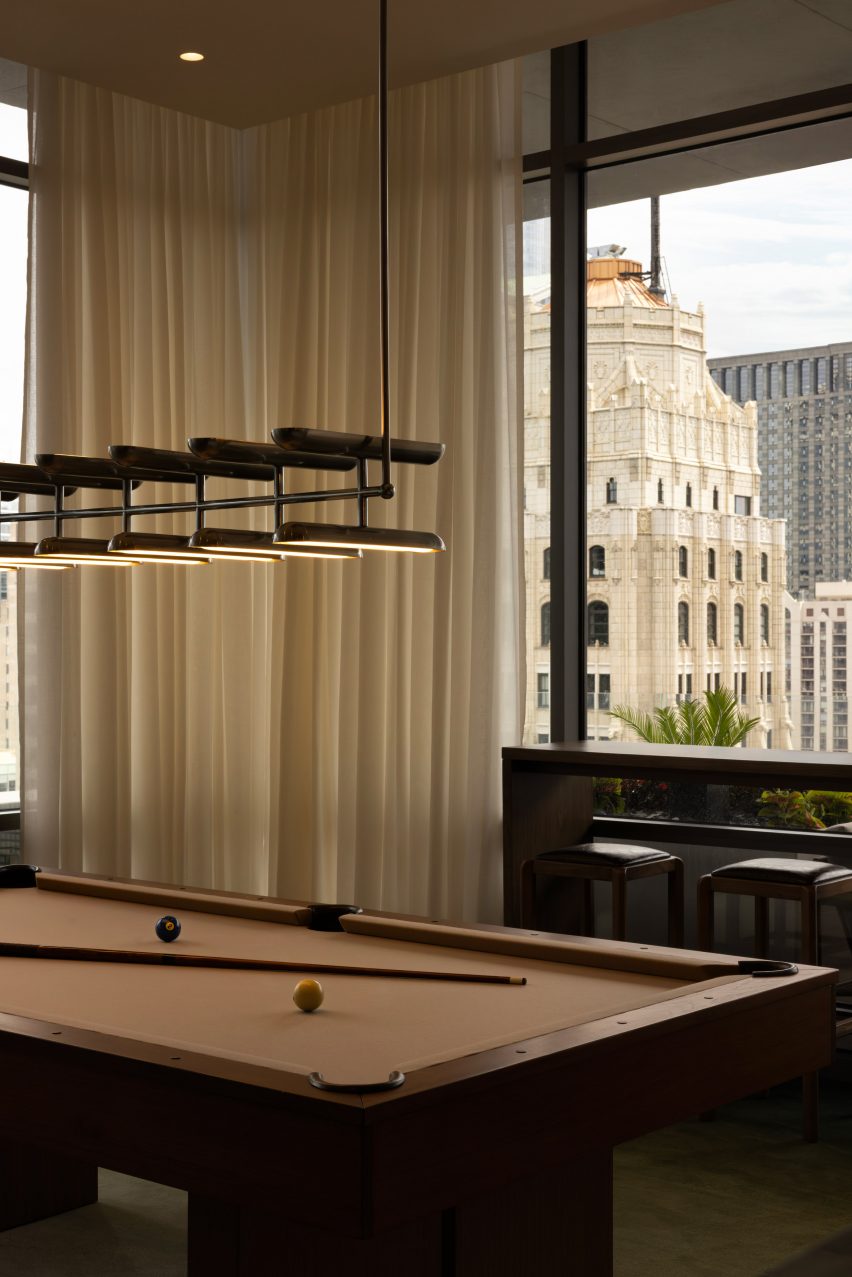 Brown pool table with a view of the Chicago skyline behind
