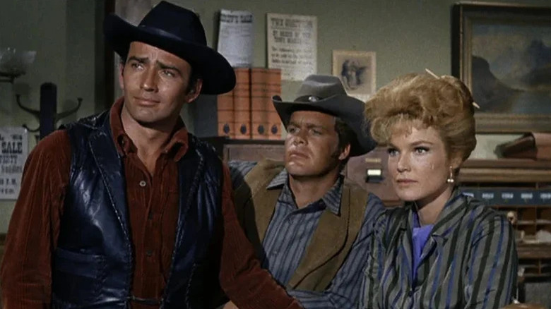 The Virginian (James Drury) stands next to Trampas (Doug McClure) and Betsy Garth (Roberta Shore) on The Virginian